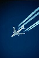747 jumbo jet at high altitude with contrails.